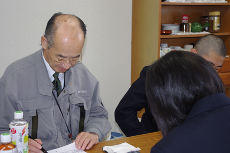 株式会社嵯峨商店の嵯峨社長とお話に真剣に聞き入る大野高校の学生